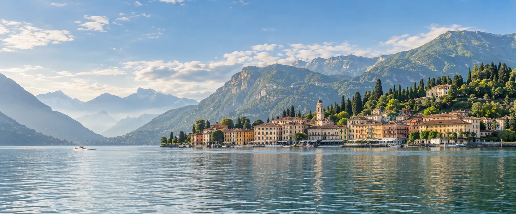 Lake Como village waterfront below wooded mountains in soft morning light
